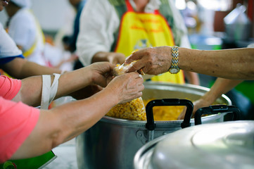Volunteer food servers dish out a free charity : concept of helping