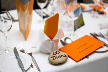 fully set table with white and orange decoration and a nametag diana