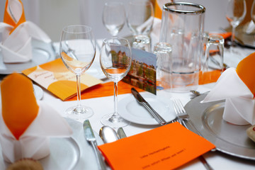 Close up of a fully set banquet table with orange decoration