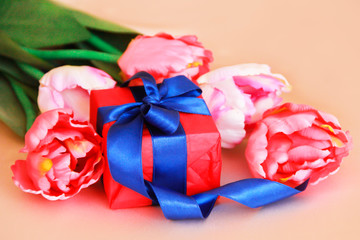 pink tulips and decorative gift box with a bow for the holiday of March 8