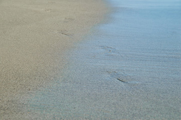 Close up. Italy, Rome, Ostia. Coast of the Tyrrhenian Sea. Footprints in the wet sea sand. Copy space.