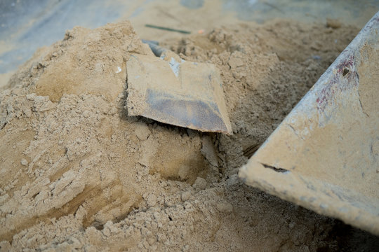 Shovel placed on a pile of sand for construction work