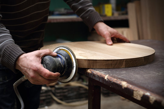 Szlifowanie desek. Stolarz szlifuje drewniany blat.