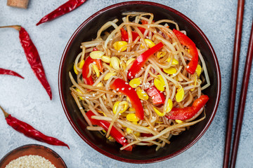 Soybean sprouts (Seedlings) salad with bell peppers, onions, garlic, spices and sesame seeds. Delicacy Oriental dish (Korean, Japanese, Chinese). Vegetarian snack. Selective focus