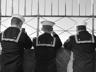 3 united states navy sailors on top of the Empire State Building looking at the views