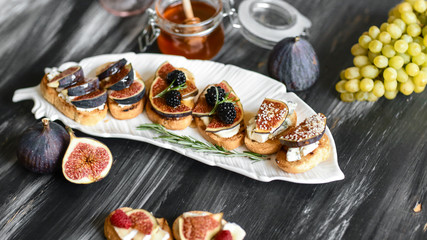 Canape or crostini with toasted baguette with cheese, figs and honey. Delicious appetizer, ideal as...