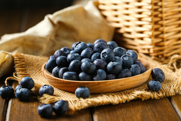 Fresh blueberries in wooden plate on a wooden table