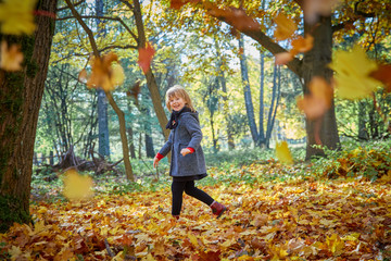 Girl playing with autumn leaves.