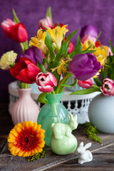 Bunte Fruehlingsblumen in kleinen Vasen