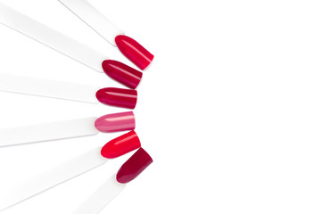 Nail art color palette. Set of red artificial nails and manicure samples, isolated on white...