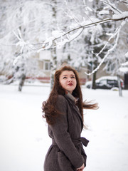Portrait of a beautiful girl in a coat. Snowy day