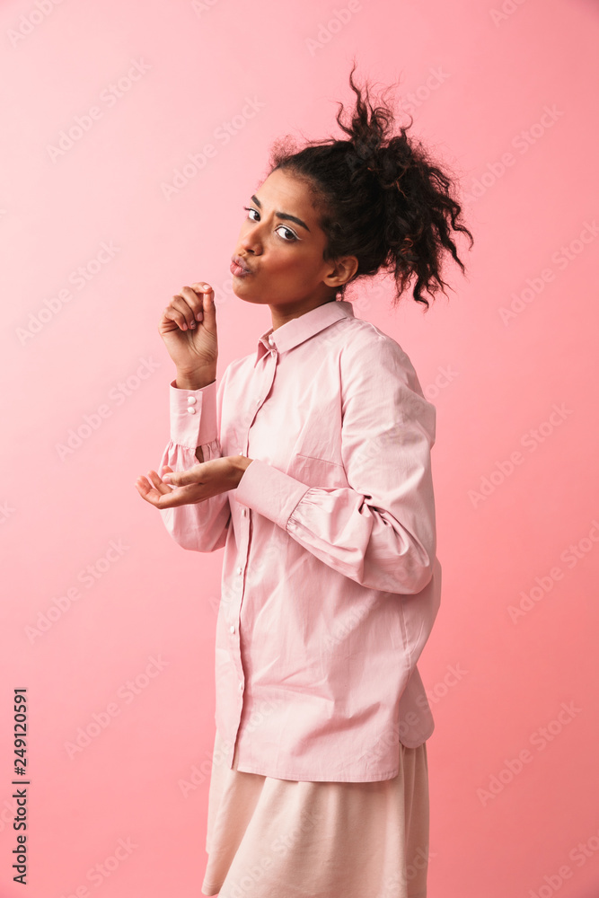 Poster beautiful young african woman posing isolated over pink wall background imagine that she drinking te