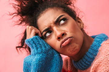 Tired bored young african woman posing isolated over pink wall background.