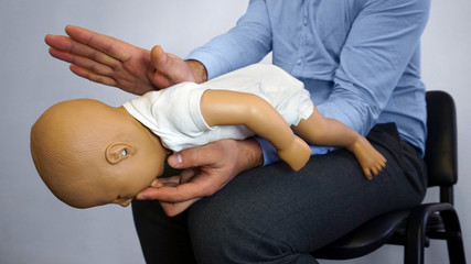 Back blows (the Heimlich maneuver or Heimlich manoeuvre) on a simulation mannequin infant dummy during medical training Basic Life Support