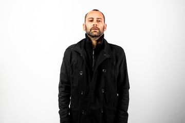 Simple and clean portrait of middle-aged man wearing his black raincoat to hide his face.