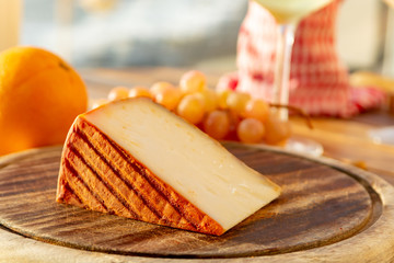 Spanish goat milk cheese with paprika coating and ripe pink table grapes