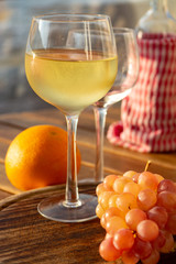 Aperitif cold white wine served in glasses with pink grapes on outdoor tessace witn sea view