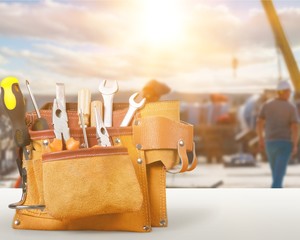 Tool belt with tools on wooden background
