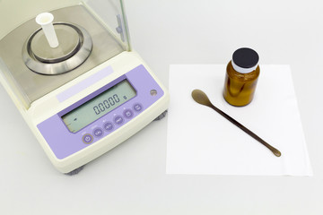 laboratory scale on table with materials in bottles.