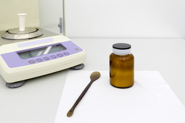 laboratory scale on table with materials in bottles.