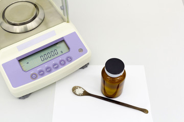 laboratory scale on table with materials in bottle.