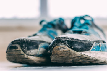 old ripped sneakers on white and light background