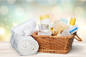 Fototapeta na wymiar Bath towel and basket with accessories for spa on blur background