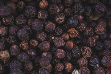 Black pepper peppercorns background. Natural seasoning texture.