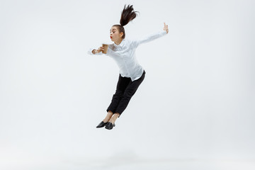 Happy businesswoman dancing and smiling in motion isolated on white studio background. Flexibility and grace in business. Human emotions concept. Office, success, professional, happiness, expression