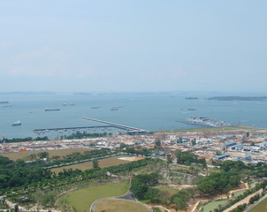 Fototapeta premium Landscape from the skyline of the ocean bay near the port city with a large number of diverse ships on the sea horizon on a sunny day.