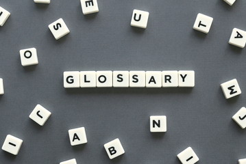 Glossary word made of square letter word on grey background.