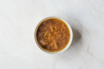 French Onion Soup with Bread on Marble Surface.