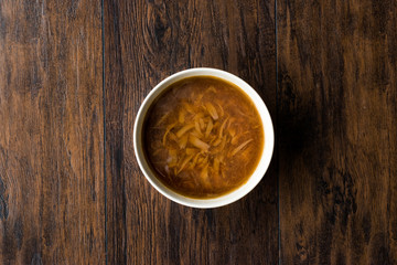 French Onion Soup with Bread on Dark Wooden Surface.