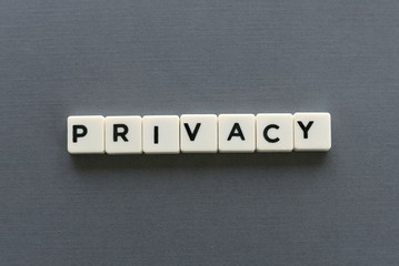 Privacy word made of square letter word on grey background.