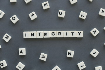 Integrity word made of square letter word on grey background.