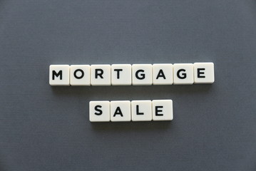 Mortgage sale word made of square letter word on grey background.