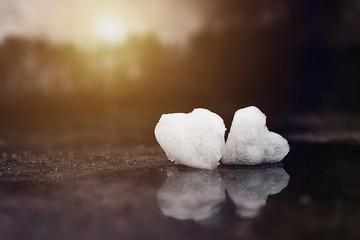 Two Valentine's Day Hearts formed from snow on rock surface.