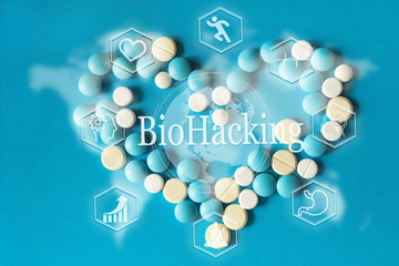 White and yellowWhite  round pills are poured against a blue white plastic pill background. view from above. drug. concept of biohacking