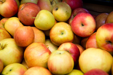 fresh fruit, many ripe red apples on the counter in the supermarket