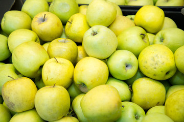 fresh fruit, many ripe apples on the counter in the supermarket