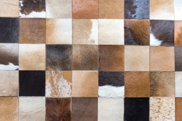 The background of the square cow leather comes together into a geometric pattern, used to decorate the walls, textures, wallpapers, designs on paper. - obrazy, fototapety, plakaty
