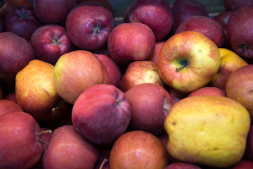 fresh fruit, many ripe red apples on the counter in the supermarket