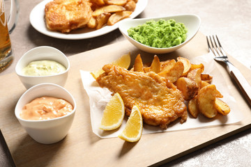British traditional fish, potato chips and mushy peas on color background