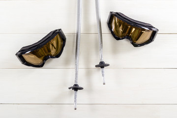 Overhead view of ski accessories placed on rustic white wooden table.