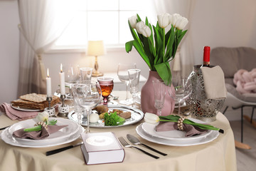 Festive Passover table setting with Torah at home. Pesach celebration