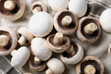 Fresh champignon mushrooms on fabric, top view