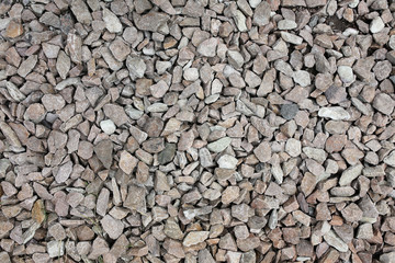Grey stone chippings lying on the ground outdoors. Natural background texture.