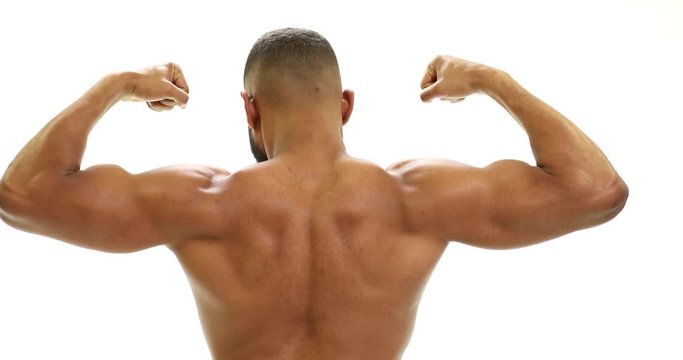 Strong fit African American athletic man flexing biceps and back muscles in front of a white background. Shot from the back in 4k slow motion at 30 fps.mov