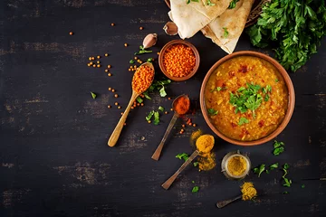 Fototapeten Indian dal. Food. Traditional Indian soup lentils.  Indian Dhal spicy curry in bowl, spices, herbs, rustic black wooden background. Top view. Authentic Indian dish. Overhead. Flat lay © timolina