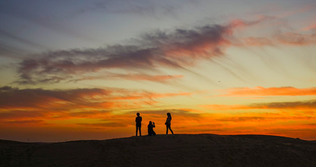 Young people enjoying the sunset on desert